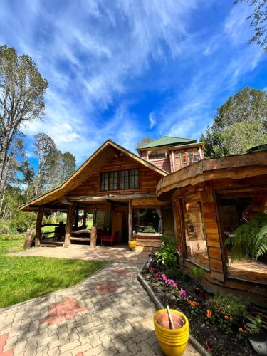 uma casa de madeira com um alpendre e um pátio em Valle el Abra Ralún Lodge em Puerto Varas