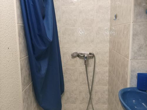 une douche avec un rideau de douche bleu dans une salle de bain dans l'établissement Charmant studio au Sauze pour 3 pers. avec balcon, box à ski et option ménage - FR-1-165A-171, à Enchastrayes