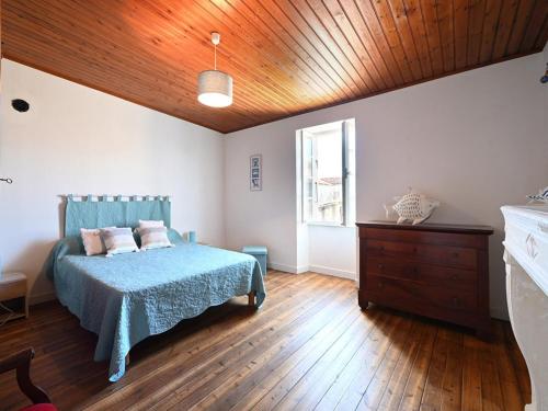 - une chambre avec un lit bleu et un plafond en bois dans l'établissement Maison de village à Ars-en-Ré avec garage, cour, salon TV, 3 chambres, balcon et équipements modernes - FR-1-434-104, à Ars-en-Ré