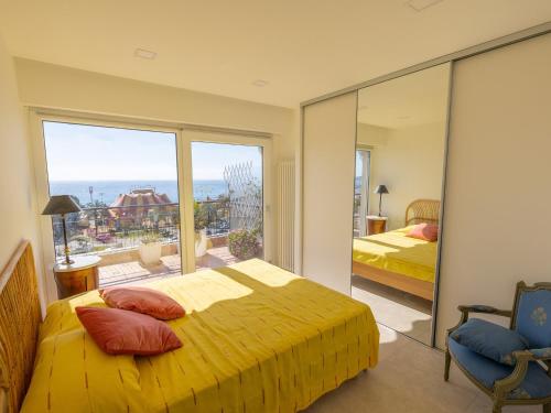 a bedroom with a yellow bed and a large window at Magnifique 3P climatisé en dernier étage avec terrasse face mer, proche centre Menton - FR-1-196-326 in Menton