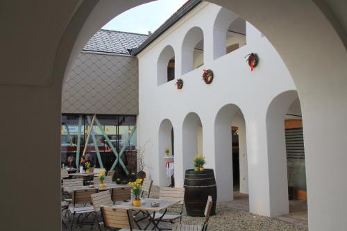 an outdoor patio with tables and chairs and a building at Hotel Eisenhuthaus in Poysdorf