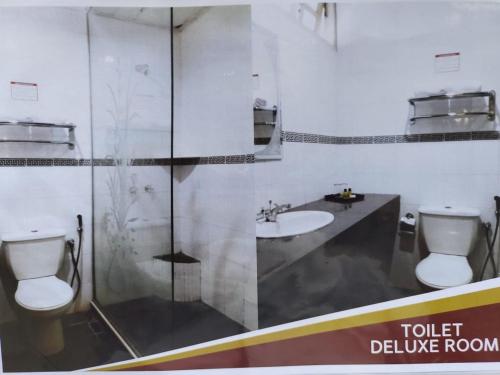 uma casa de banho com um WC, um lavatório e um chuveiro em Shah's Beach Resort Melaka em Malaca