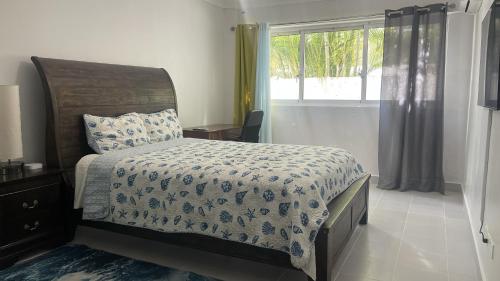 een slaapkamer met een bed en een raam bij Acogedor Apartamento a pasos de la playa caribeña Bavaro in Punta Cana