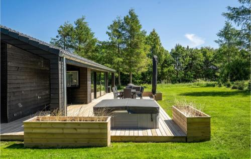 a wooden deck with a grill in a yard at 4 Bedroom Nice Home In Glesborg in Glesborg