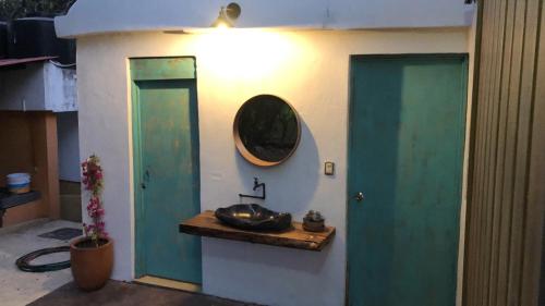 a bathroom with a sink and a mirror on a wall at Cocuyo Glamping in San Agustín Etla
