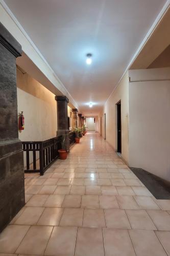 a long hallway with a tile floor and a white wall at Hotel YMCA - Near Meenakshi Amman Temple Madurai in Madurai