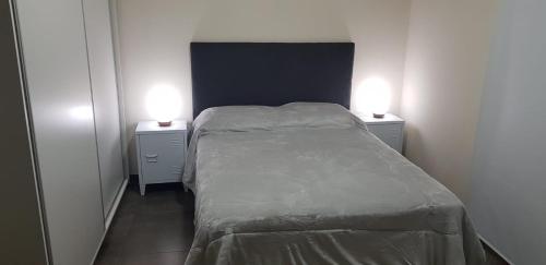 um pequeno quarto com uma cama com duas luzes em Dpto Falucho em San Luis