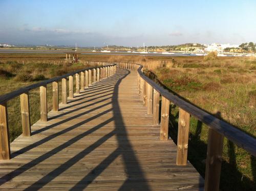 a wooden boardwalk leading to the beach at The Birds Nest in Alvor