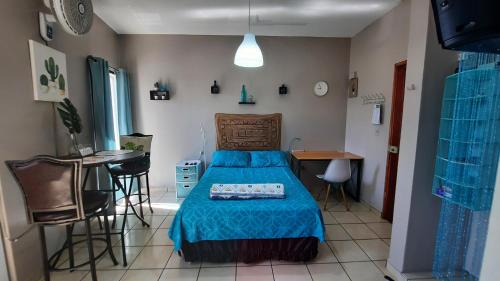 a bedroom with a bed and a table and chairs at Encantador Apartamento Equipado in Tegucigalpa
