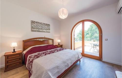 a bedroom with a bed and a large window at 3 Bedroom Stunning Home In Vabriga in Vabriga