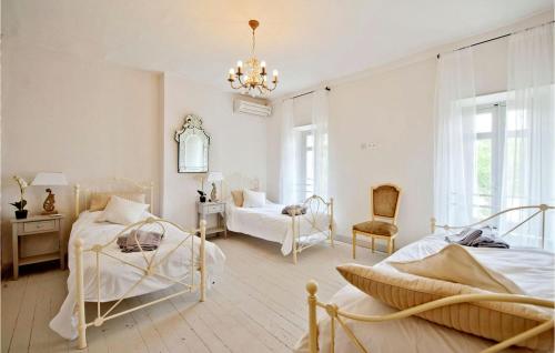 1 dormitorio con 2 camas y lámpara de araña en Amazing Home In Canet With Private Swimming Pool, Can Be Inside Or Outside, en Canet d'Aude