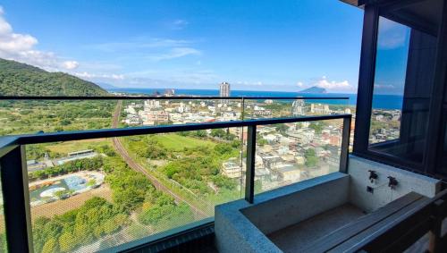 a balcony with a view of a city and the ocean at 漫遊小旅泳池溫泉宅 Roaming Travel Hot Spring Homestay in Toucheng