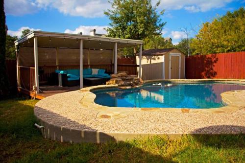 a swimming pool in a backyard with a pavilion at Home Away From Home (w/ Pool) in San Antonio