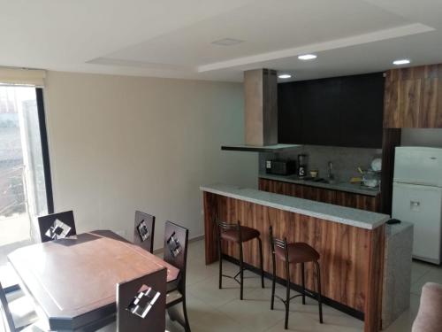 a kitchen with a counter and a table and chairs at Departamento acogedor, nuevo y Amplio in Cuenca