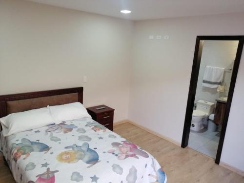 a bedroom with a bed and a mirror at Departamento acogedor, nuevo y Amplio in Cuenca