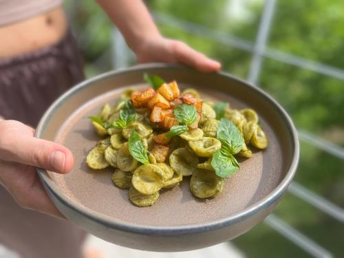a person holding a bowl of food with vegetables at Kapuhala Sicily in Marzamemi