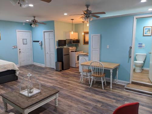 a room with a bed and a table and a kitchen at Cozy studio with movie theater, beach 5 min away in Morehead City