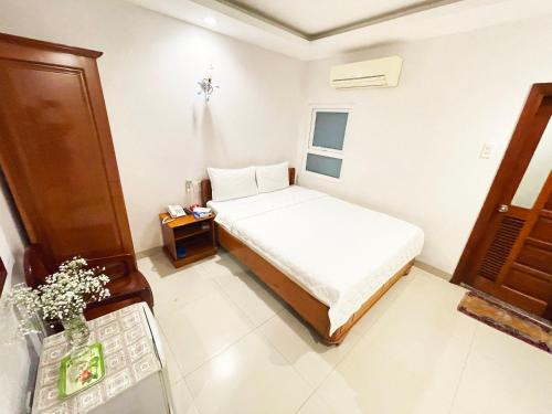een kleine slaapkamer met een bed en een tafel bij Khách sạn Nắng Biển - Sunny Sea in Nha Trang