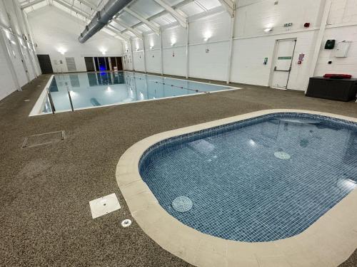 a large swimming pool in a large building with a swimming pool at Oyster Cottage in Filey