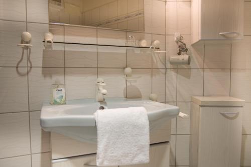 Baño blanco con lavabo y toalla en Meeresbrandung FeWo 36, en Cuxhaven