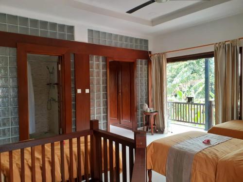 a bedroom with a bed and a balcony at Villa casamarbella in Karangasem