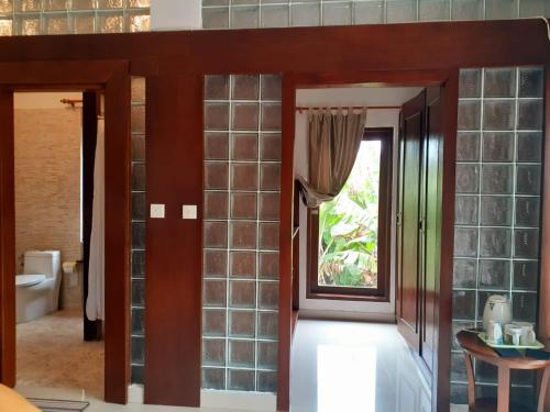 a bathroom with glass block walls and a window at Villa casamarbella in Karangasem