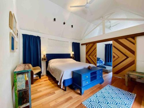 una camera con un letto e un tavolo blu di Luxury & Tropical Villa Te Nunoa, Haapiti Moorea a Haapiti