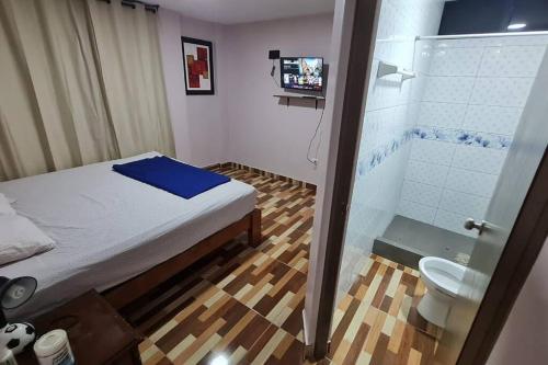 a bedroom with a bed and a shower and a toilet at CASA VIP PIURA, piscina privada, full amoblada in Piura
