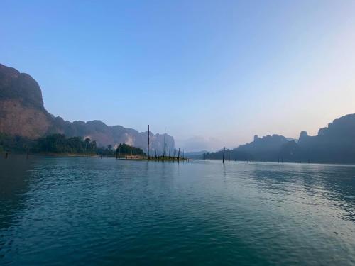 a large body of water with mountains in the background at Boom Hostel Khao Sok in Khao Sok