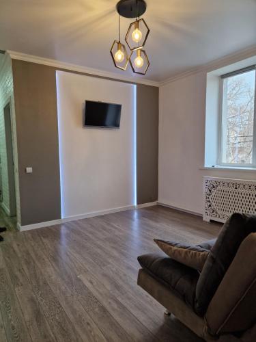 sala de estar con sofá y TV en la pared en Stail en Bălţi