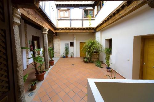 an empty courtyard with potted plants in a building at Apartamentos del Casco in Toledo