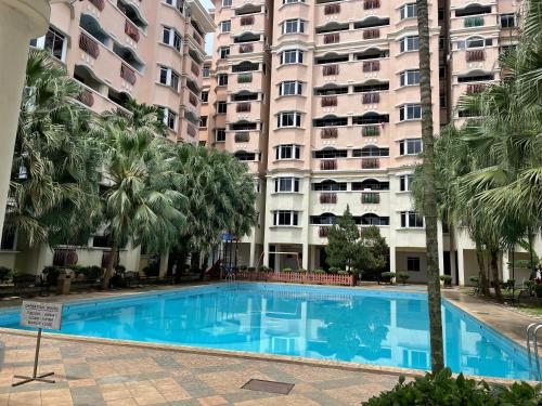 una piscina frente a un gran edificio de apartamentos en KUHARA COURT APARTMENT SUITE en Tawau