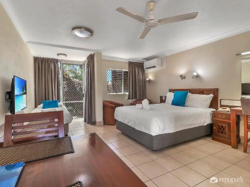 a hotel room with a bed and a television at Studio 3 ENDEAVOUR INN in Emu Park