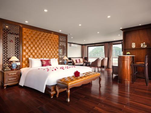 a bedroom with a large bed and a living room at Aqua Of The Seas Cruise Halong in Ha Long