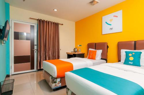 Кровать или кровати в номере Sans Hotel Finest Medan