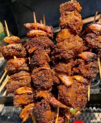 a pile of food cooking on a grill at Palazzo Apartments in Ikeja
