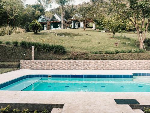 a swimming pool in front of a house at VOLARE Experience in Guatapé