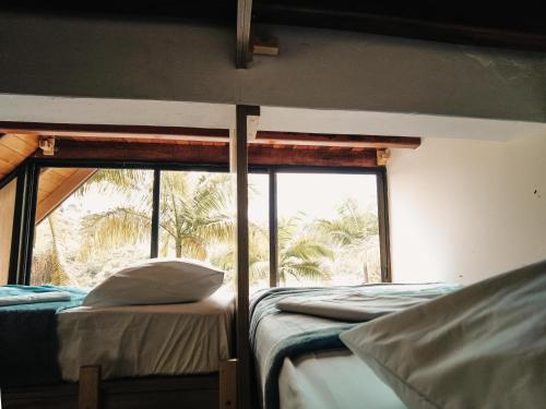 a room with two beds and a large window at Volare Guatapé isla de descanso y retiro in Guatapé