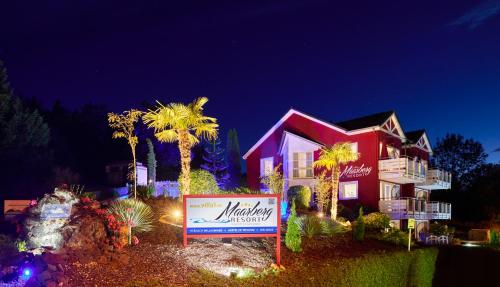 a house with a sign in front of it at night at Maarberg Resort in Schalkenmehren