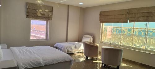 a hospital room with two beds and a window at Marina H in Sohar