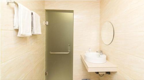 a bathroom with a sink and a mirror at Osaka Hotel Batam in Nagoya