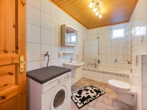a bathroom with a washing machine and a toilet at Comfortable house with a garden and parking in Roes