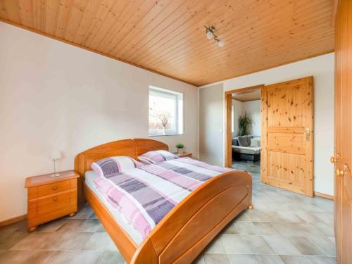 a bedroom with a wooden bed and a wooden ceiling at Comfortable house with a garden and parking in Roes