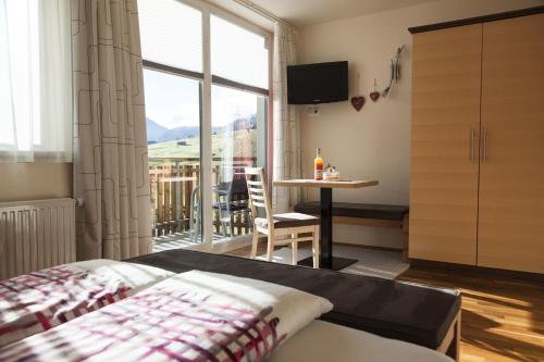 a bedroom with a bed and a table and a window at Haus Sonneneck - ski in & out in Sankt Anton am Arlberg