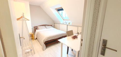 um pequeno quarto com uma cama e uma mesa em Chambre à la Campagne 1o minutes gare TGV 