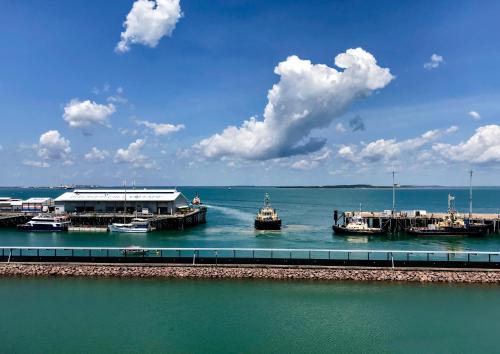 a group of boats docked at a dock in the water at Absolute Waterfront - Tropical Oasis Over The Water in Darwin