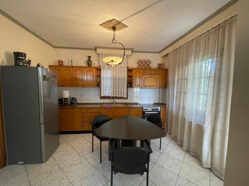 uma cozinha com uma mesa e um frigorífico em Nea Peramos Large Apartment Near the Beach em Nea Peramos