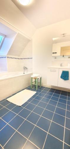 uma casa de banho com piso em azulejo azul e um lavatório. em Chambre à la Campagne 1o minutes gare TGV 