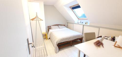 Dormitorio pequeño en el ático con cama y ventana en Chambre à la Campagne 1o minutes gare TGV 