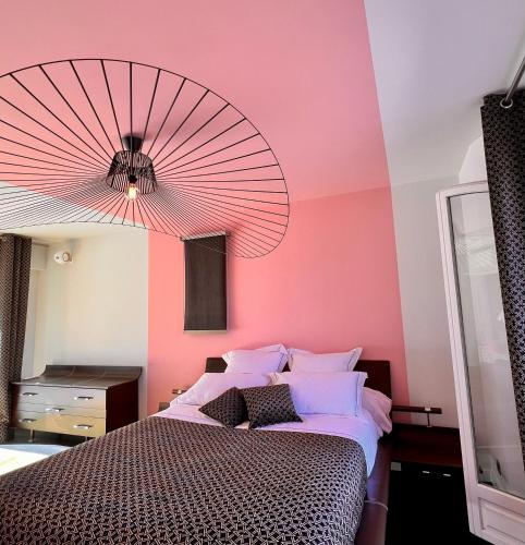 a bedroom with a large bed with a pink wall at Villa familiale avec vue imprenable in Saint-Raphaël